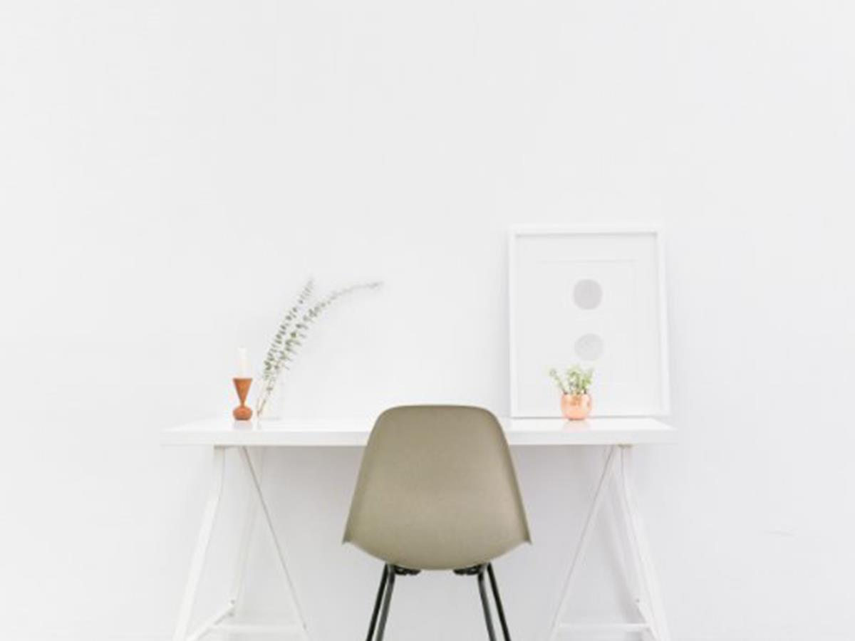 A work desk in front of a white wall.